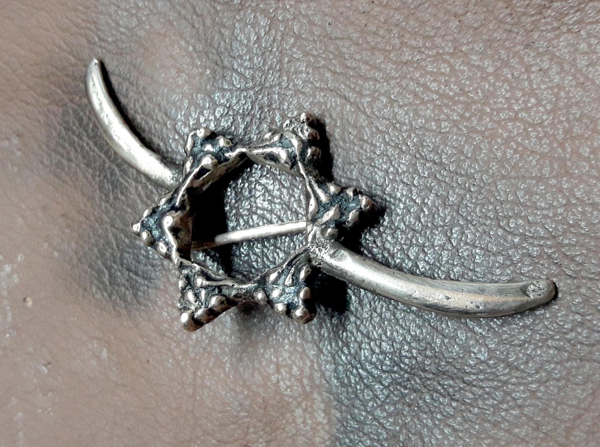 Anstecknadel aus Bronze – künstlerisch angelehnt an einen der 796 Spangenbarren aus Oberding – vereint mit dem Logo des AVE e.V. Entworfen und hergestellt in über 30 ehrenamtlichen Stunden von unserem „Vereins-Schmied und –Bronzegießer“ Johannes Goldes Foto: Johannes Goldes