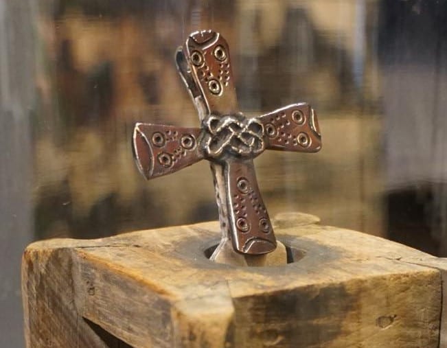 Anstecker aus Bronze – Kreuzfibel mit Kreisaugen (6./7. Jhd.; Meran) kombiniert mit Ornamentik eines Sax (6. Jhd.; Unterallgäu) – beides in Freising zur Bayer. Landesausstellung 2024 ausgestellt, Foto: Rolf Böker.