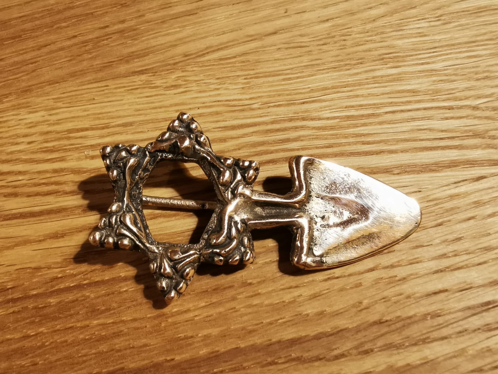 Anstecknadel aus Bronze – künstlerisch angelehnt an das Stadtwappen von Erding – Ard/Pflugschar – vereint mit dem Logo des AVE e.V. (keltischer Hohlbuckelfußring aus Klettham).  Entworfen und hergestellt in über 30 ehrenamtlichen Stunden von unserem „Vereins-Schmied und -Bronzegießer“ Johannes Goldes – ein Unikat!  Foto: Johannes Goldes